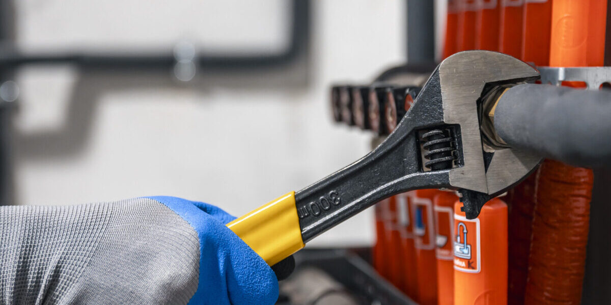 Male hands with a wrench turning off valves. Male hands with a wrench turning off valves.